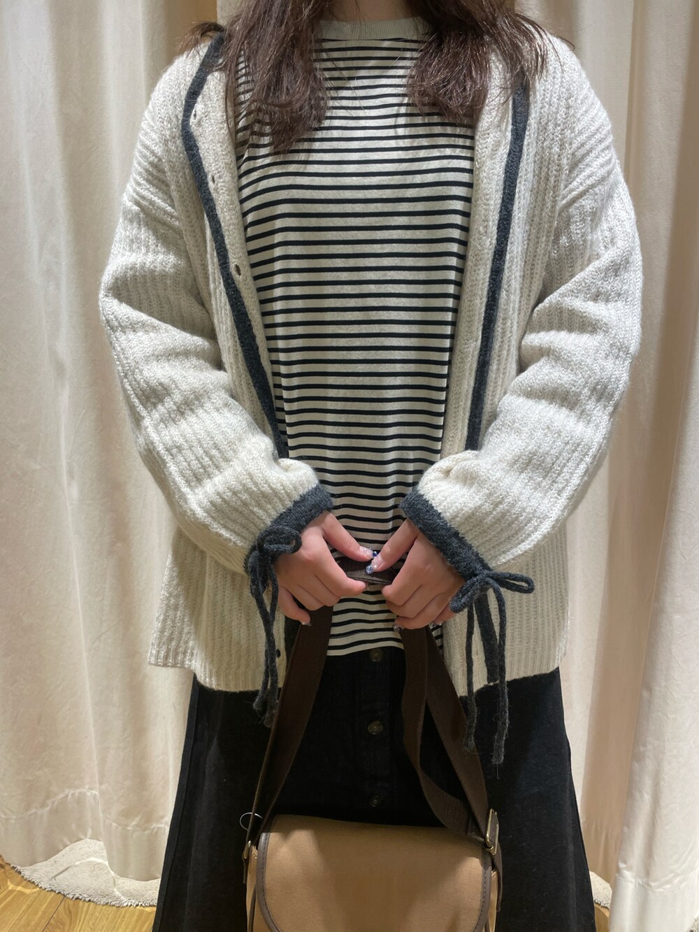 ベージュ系のTシャツ/カットソー、ホワイト系のカーディガン/ボレロ、ブラウン系のショルダーバッグを着用したレディースの冬コーディネートの5枚目の写真