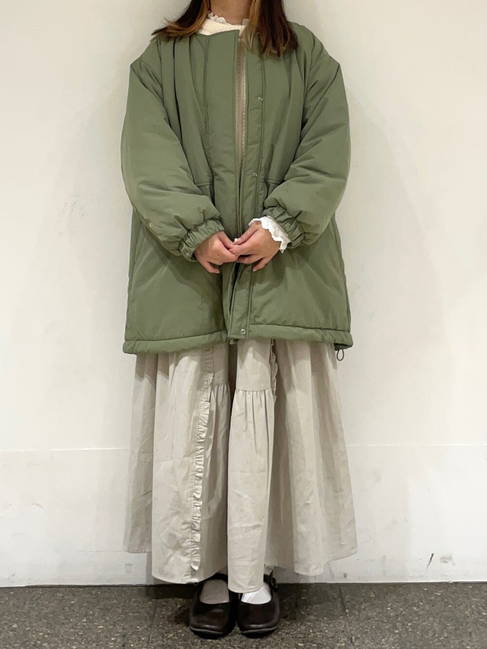 ブラウン系のドレスシューズ、ホワイト系のシャツ/ブラウス、ホワイト系のニット/セーターを着用したレディースの冬コーディネートの2枚目の写真