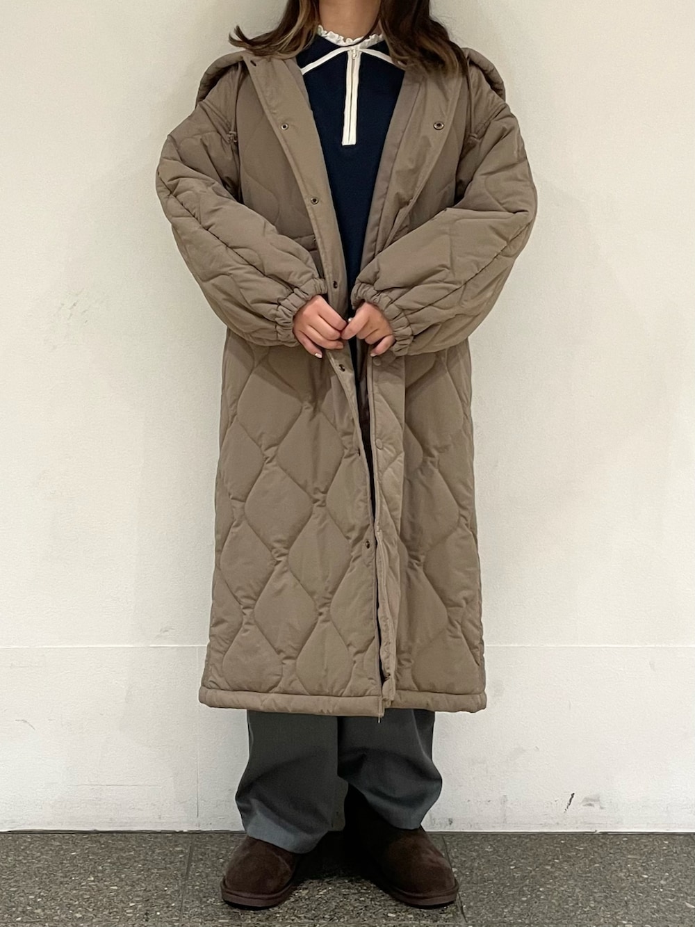 ホワイト系のTシャツ/カットソー、ブラウン系のブーツ、ブルー系のニット/セーターを着用したレディースの冬コーディネートの3枚目の写真