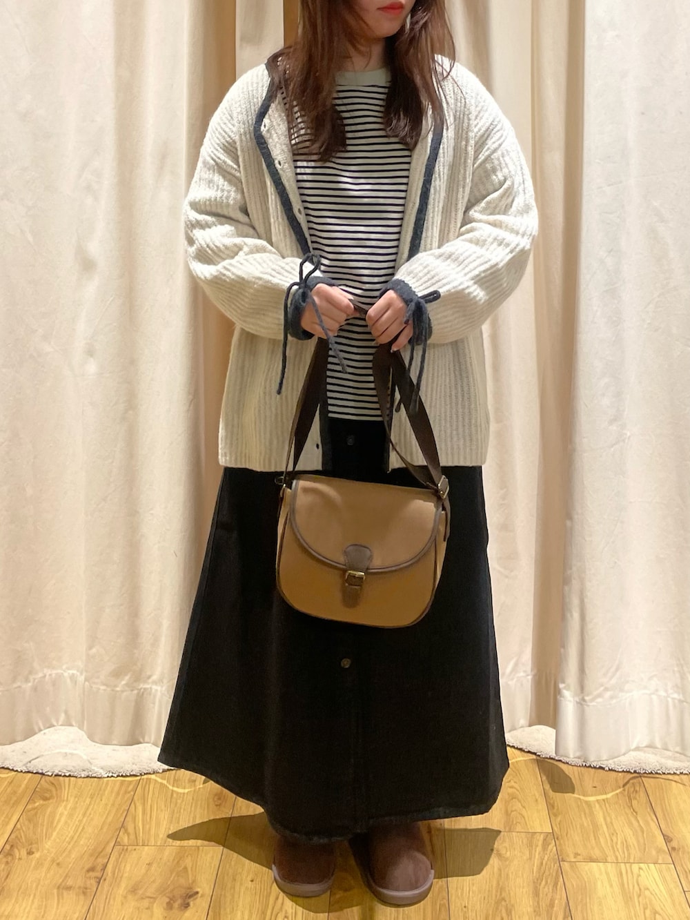 ベージュ系のTシャツ/カットソー、ホワイト系のカーディガン/ボレロ、ブラウン系のショルダーバッグを着用したレディースの冬コーディネートの4枚目の写真