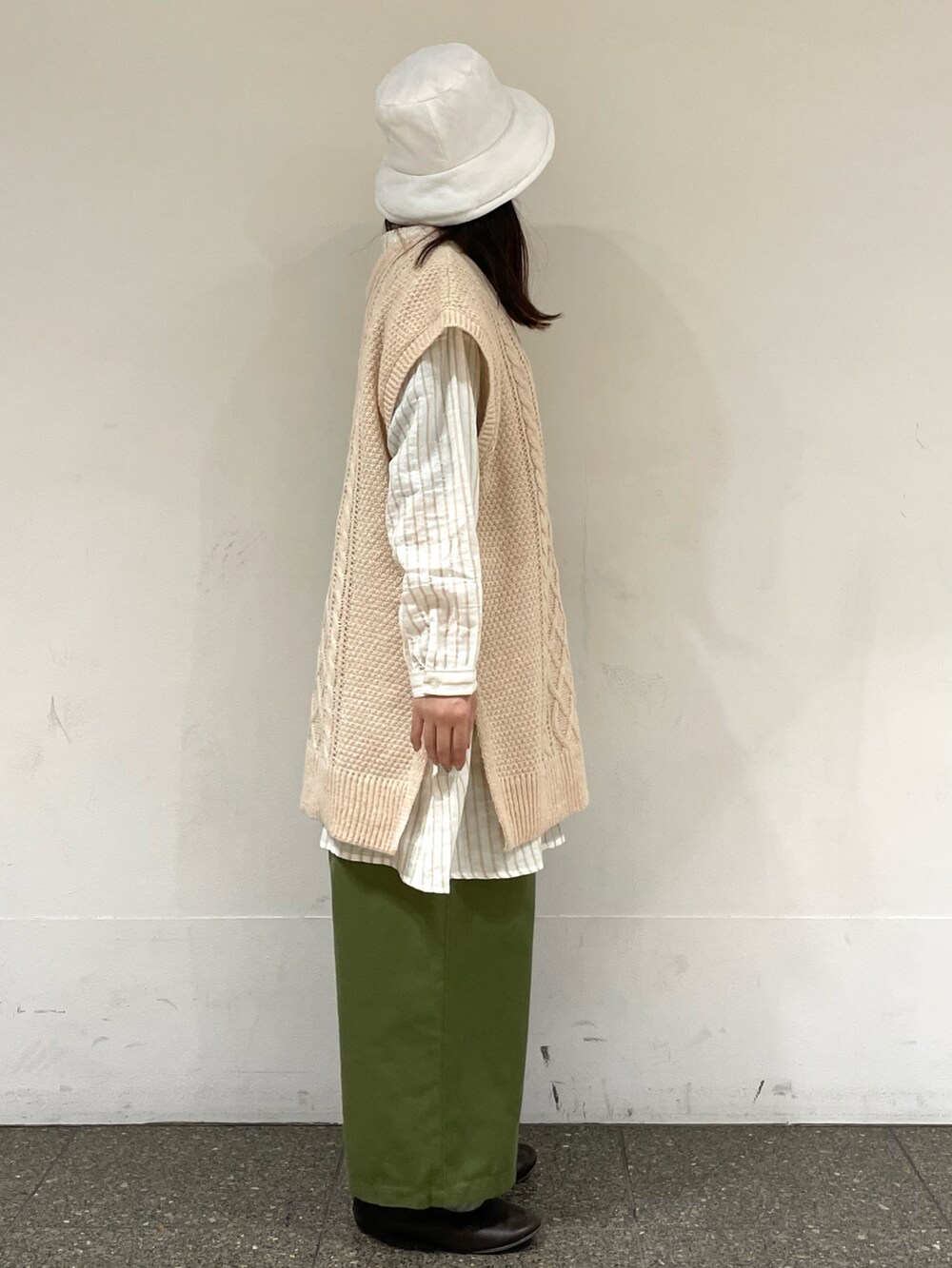 ブラウン系のドレスシューズ、ホワイト系のベスト、ベージュ系のチュニックを着用したレディースの冬コーディネートの5枚目の写真