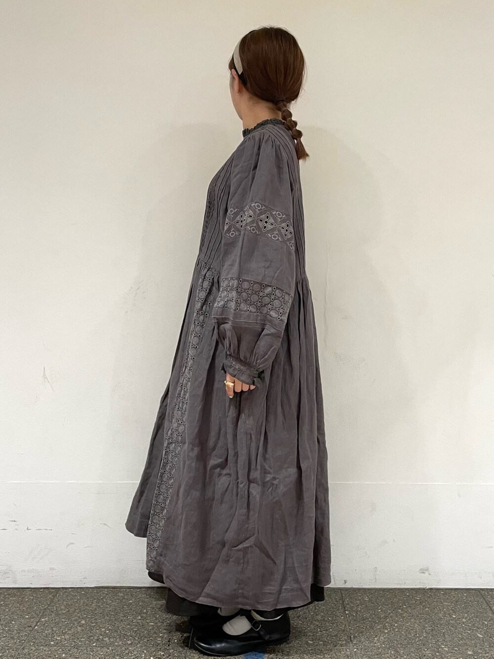 グレー系のスカート、ブラック系のドレスシューズ、グレー系のワンピースを着用したレディースの秋コーディネートの3枚目の写真