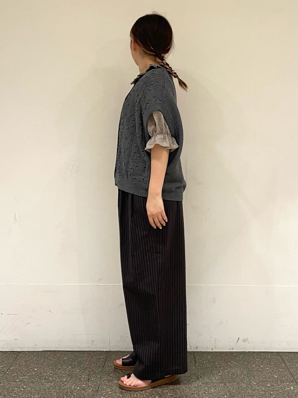 ブラウン系のサンダル、ベージュ系のシャツ/ブラウス、グレー系のベストを着用したレディースの秋コーディネートの3枚目の写真