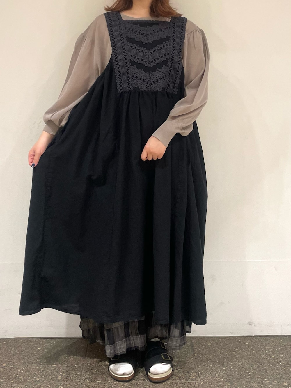 ブラウン系のカーディガン/ボレロ、ブラック系のワンピース、グレー系のスカートを着用したレディースの夏コーディネートの2枚目の写真