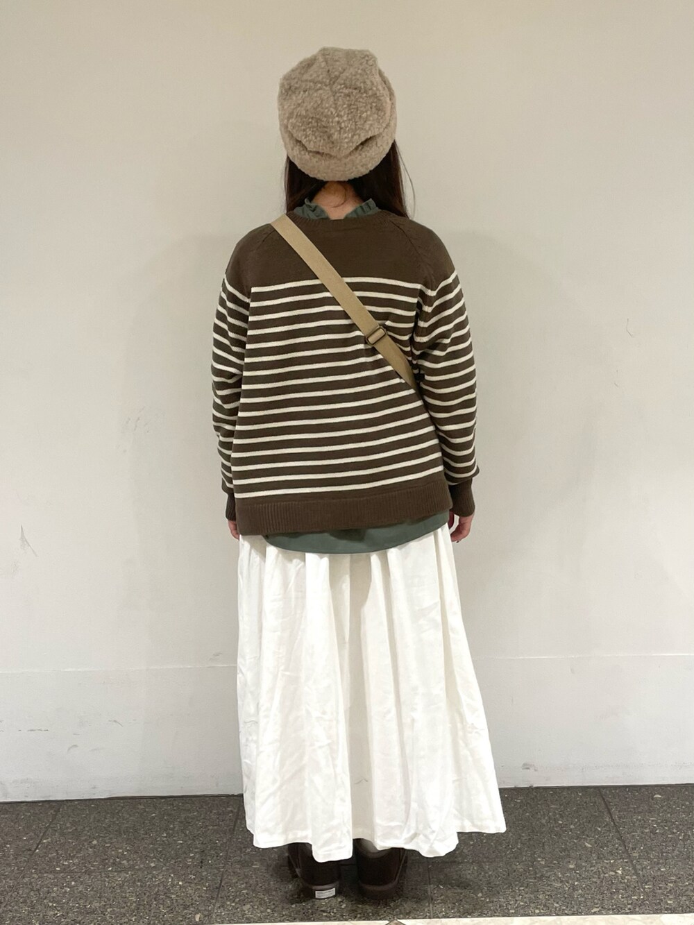 グリーン系のシャツ/ブラウス、ブラウン系のニット/セーター、ベージュ系のショルダーバッグを着用したレディースの冬コーディネートの3枚目の写真