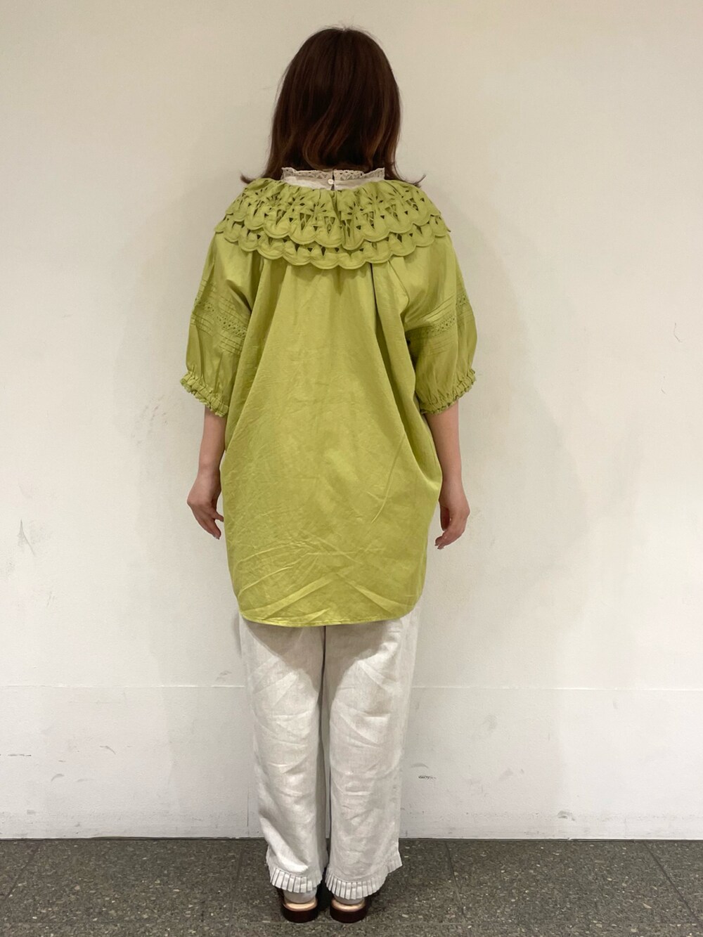 ベージュ系のタンクトップ、グリーン系のチュニック、ホワイト系のその他パンツを着用したレディースの夏コーディネートの4枚目の写真