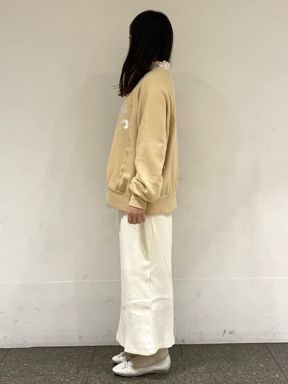 ホワイト系のパンプス、ホワイト系のTシャツ/カットソー、イエロー系のニット/セーターを着用したレディースの春コーディネートの3枚目の写真