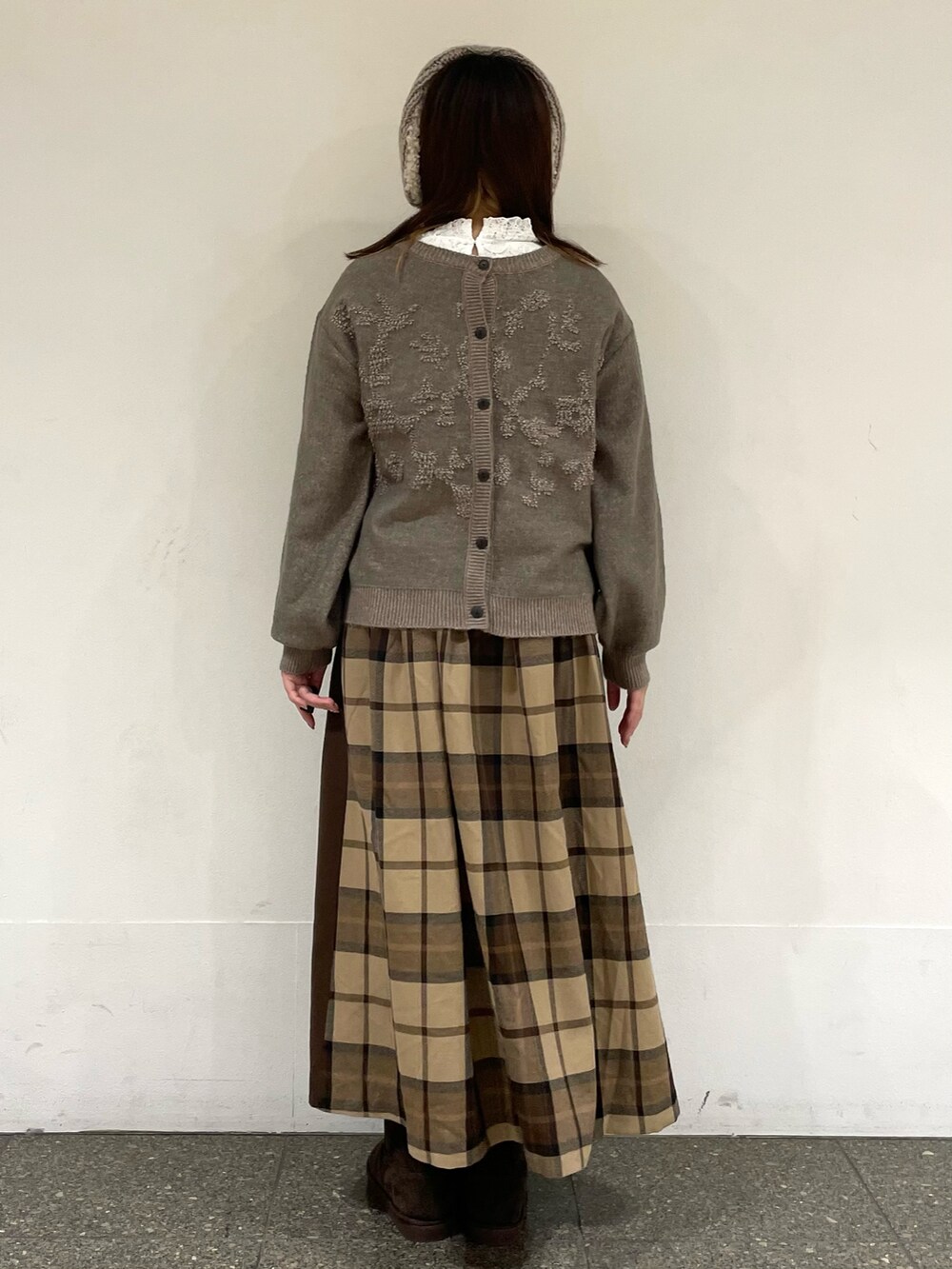 ホワイト系のTシャツ/カットソー、ブラウン系のカーディガン/ボレロ、ブラウン系のブーツを着用したレディースの冬コーディネートの4枚目の写真