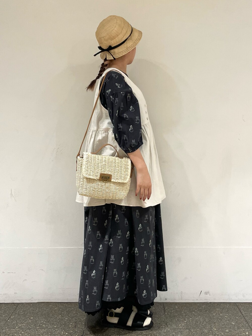 ブラック系のサンダル、ブラック系のワンピース、ホワイト系のハンドバッグを着用したレディースの夏コーディネートの5枚目の写真