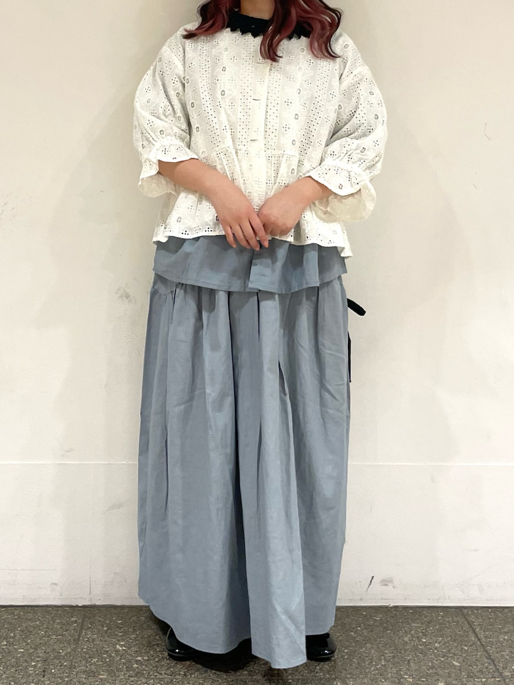 ブラック系のパンプス、ブルー系のシャツ/ブラウス、ブルー系のスカートを着用したレディースの春コーディネートの2枚目の写真