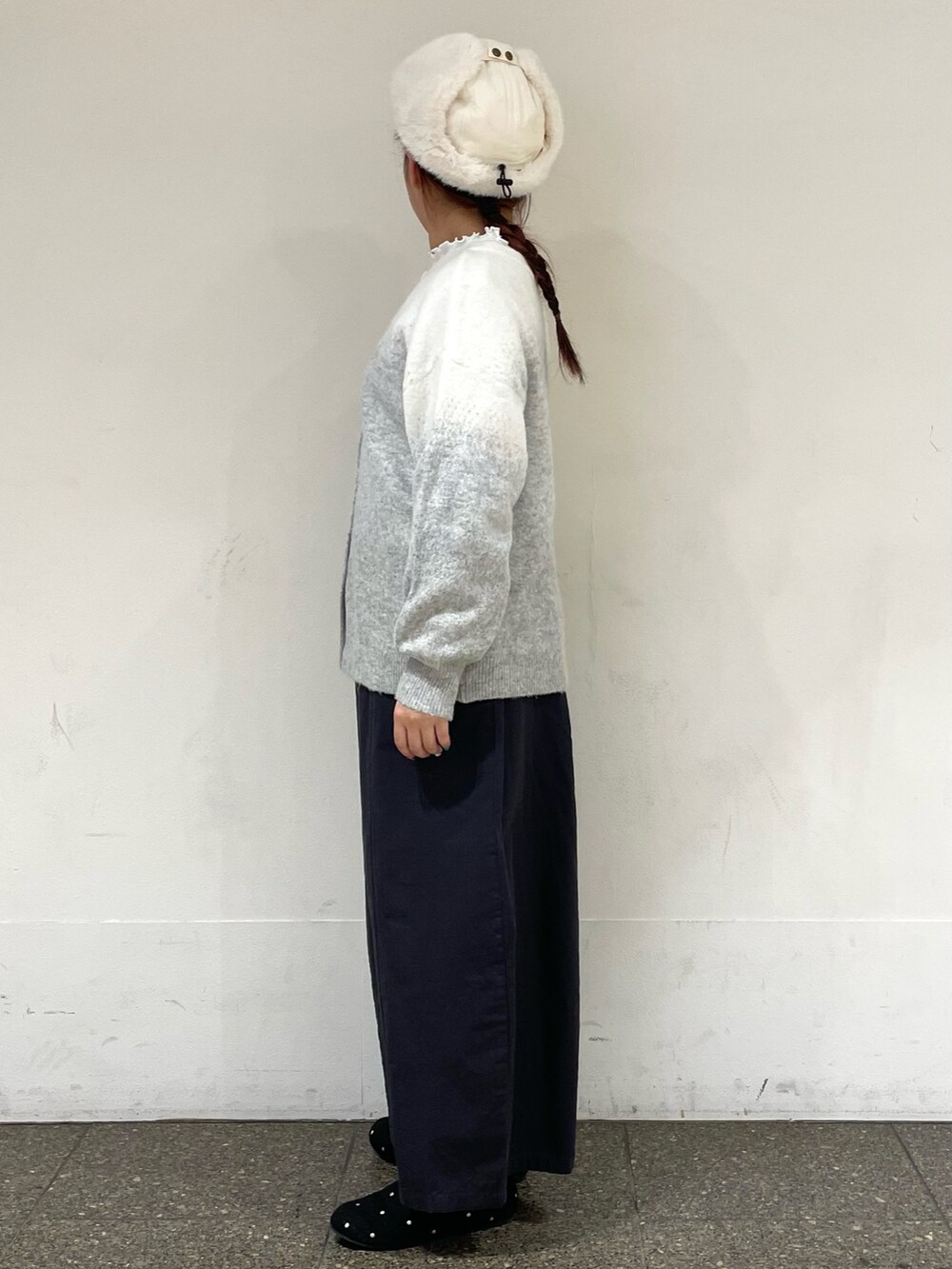 グレー系のドレスシューズ、グレー系のカーディガン/ボレロ、ホワイト系のハットを着用したレディースの冬コーディネートの3枚目の写真