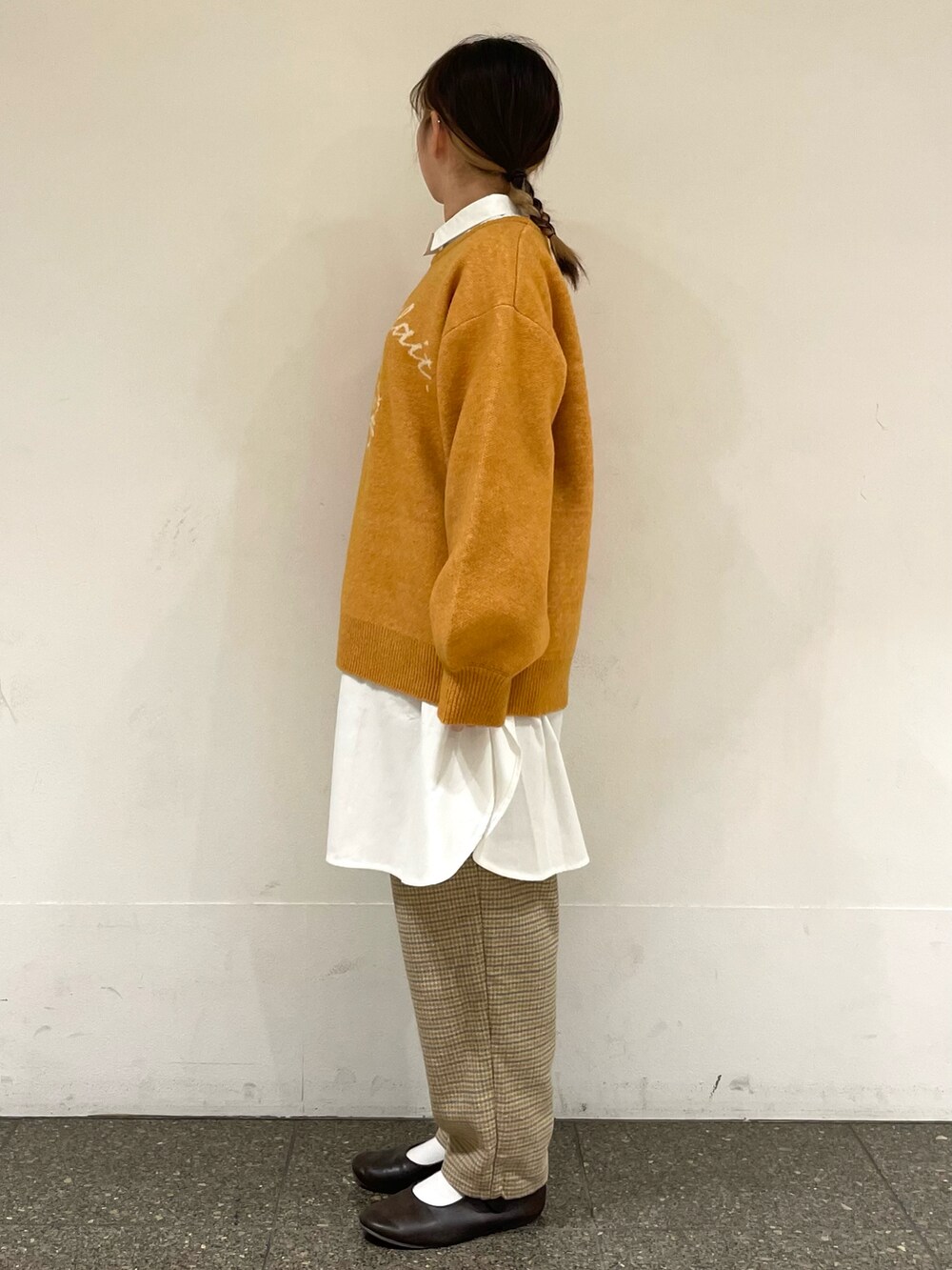 ホワイト系のチュニック、イエロー系のニット/セーター、グレー系のその他パンツを着用したレディースの冬コーディネートの3枚目の写真