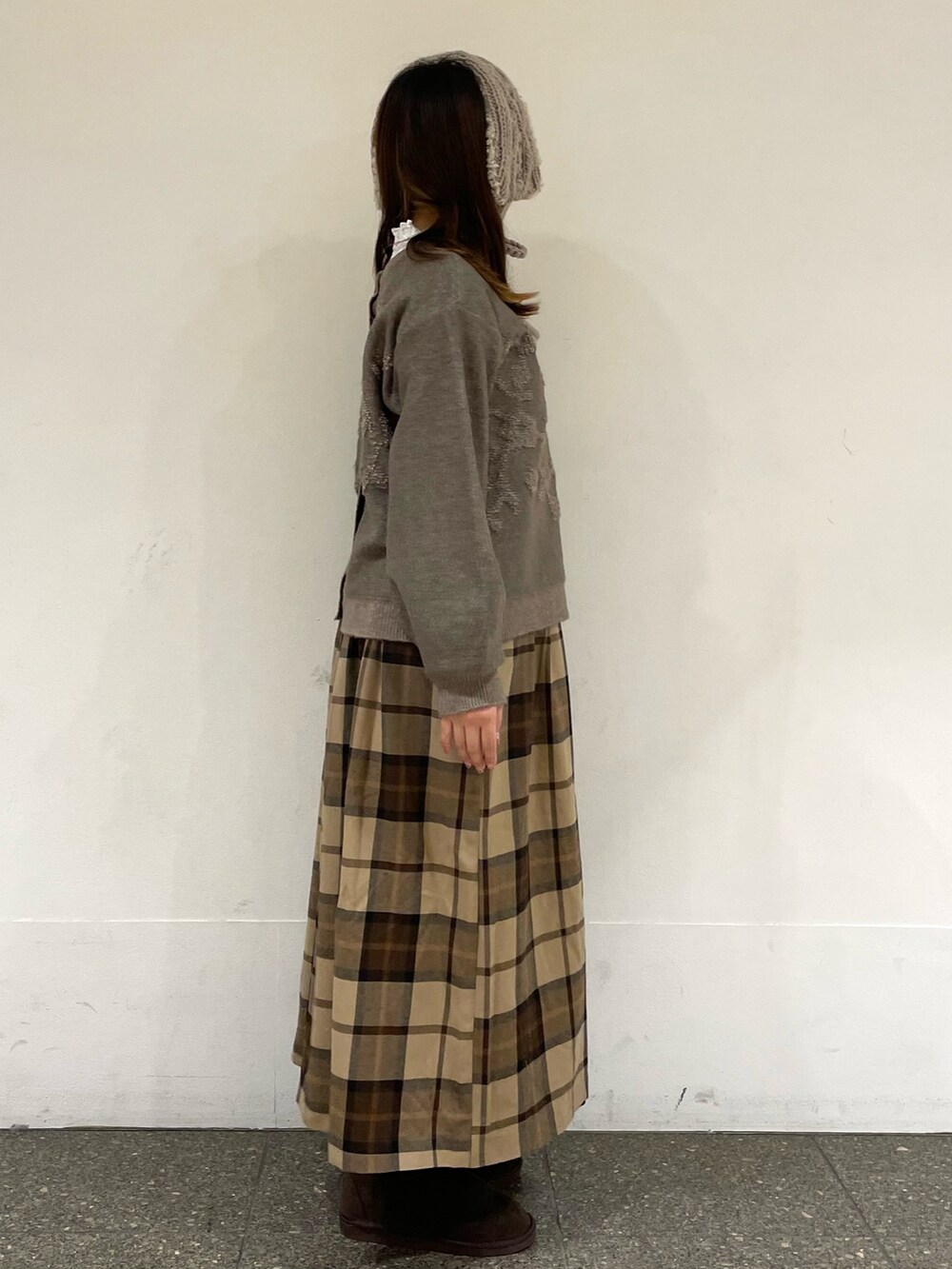 ホワイト系のTシャツ/カットソー、ブラウン系のカーディガン/ボレロ、ブラウン系のブーツを着用したレディースの冬コーディネートの5枚目の写真