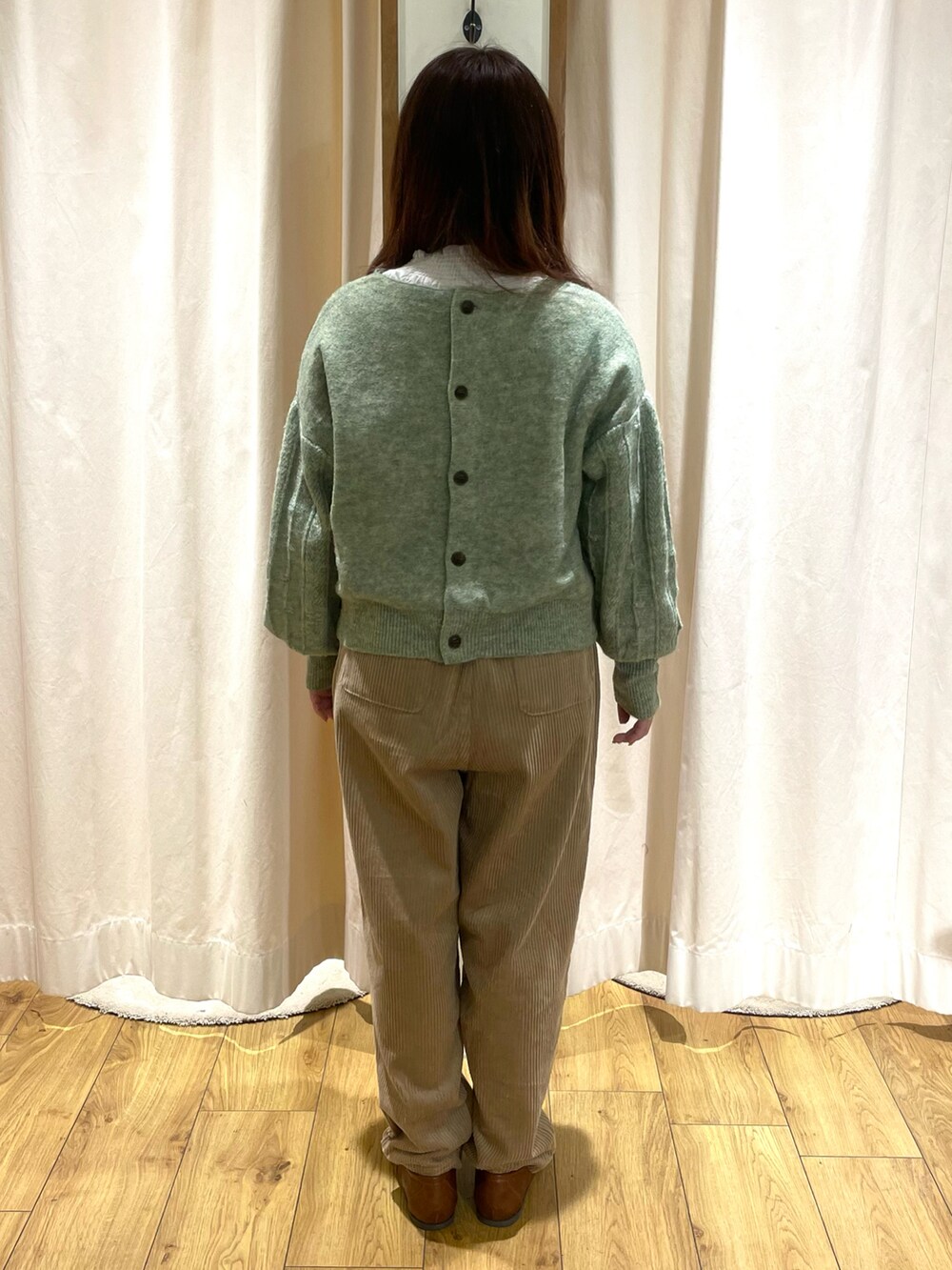 ホワイト系のシャツ/ブラウス、グリーン系のニット/セーター、ベージュ系のその他パンツを着用したレディースの冬コーディネートの3枚目の写真