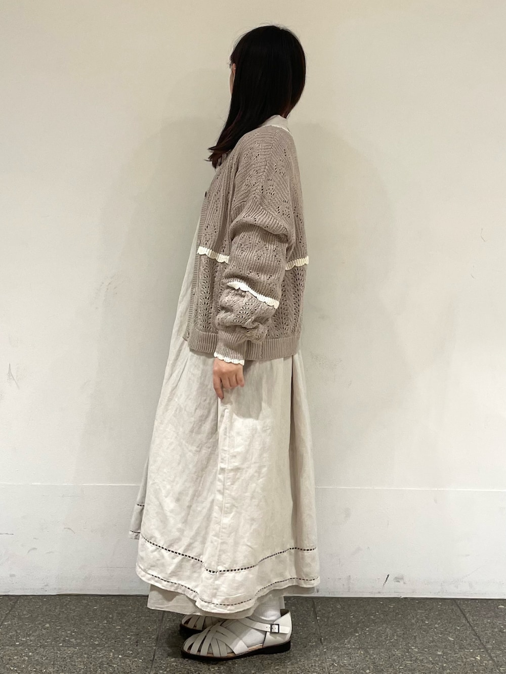 ホワイト系のサンダル、ベージュ系のカーディガン/ボレロ、グレー系のワンピースを着用したレディースの春コーディネートの3枚目の写真