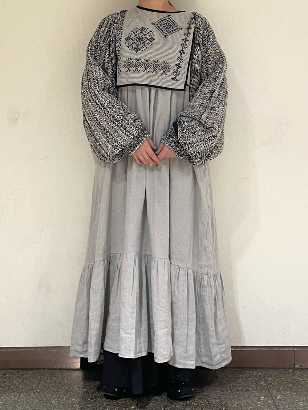 グレー系のワンピース、グレー系のドレスシューズ、ブラック系のカーディガン/ボレロを着用したレディースの冬コーディネートの2枚目の写真