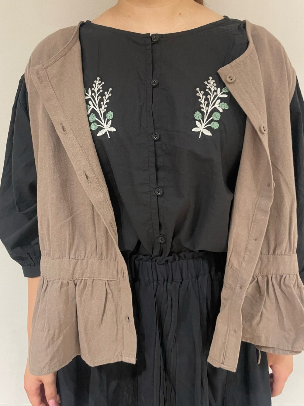 ブラック系のシャツ/ブラウス、ベージュ系のベスト、ブラック系のスカートを着用したレディースの夏コーディネートの4枚目の写真