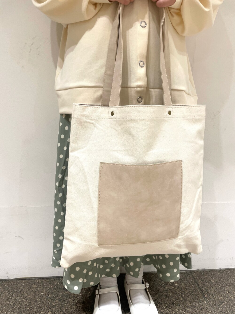 ホワイト系のTシャツ/カットソー、ホワイト系のカーディガン/ボレロ、ベージュ系のハンドバッグを着用したレディースの冬コーディネートの4枚目の写真