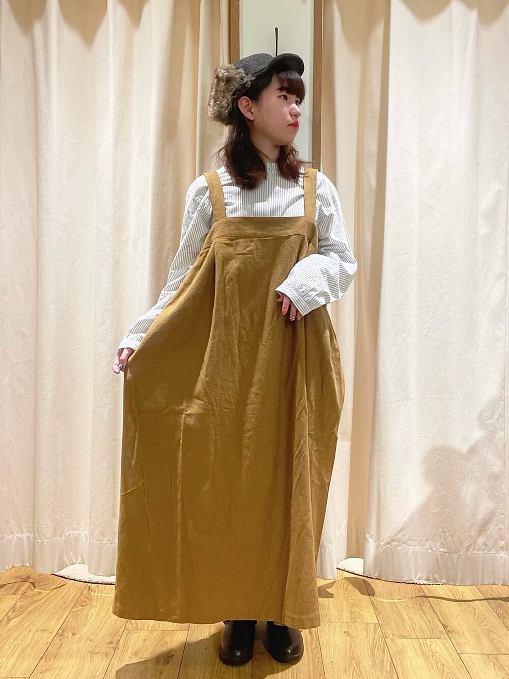 ホワイト系のシャツ/ブラウス、イエロー系のジャンパースカート、ブラウン系のサンダルを着用したレディースの秋コーディネートの2枚目の写真