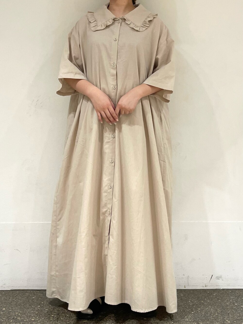 ベージュ系のワンピース、ブラック系のハットを着用したレディースの秋コーディネートの2枚目の写真