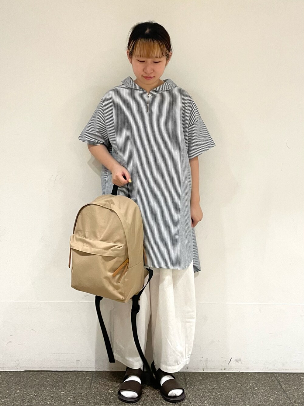 ブラウン系のサンダル、ホワイト系のその他パンツ、ベージュ系のハンドバッグを着用したレディースの秋コーディネートの2枚目の写真