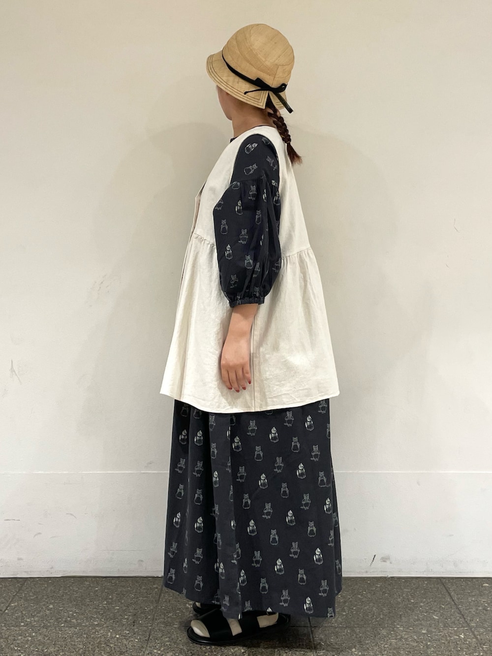 ブラック系のサンダル、ブラック系のワンピース、ホワイト系のハンドバッグを着用したレディースの夏コーディネートの3枚目の写真