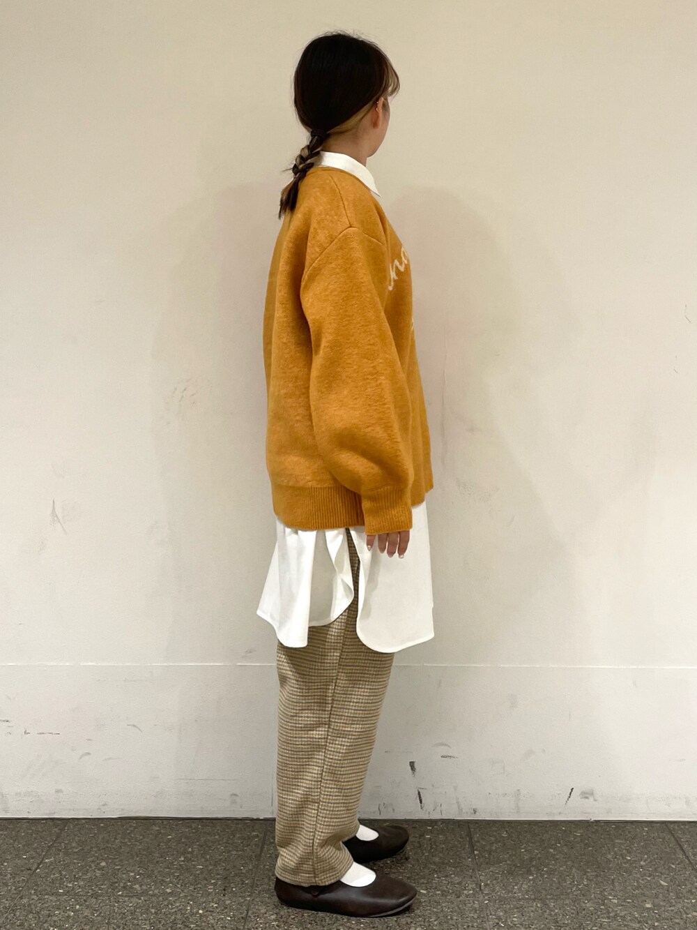 ホワイト系のチュニック、イエロー系のニット/セーター、グレー系のその他パンツを着用したレディースの冬コーディネートの5枚目の写真