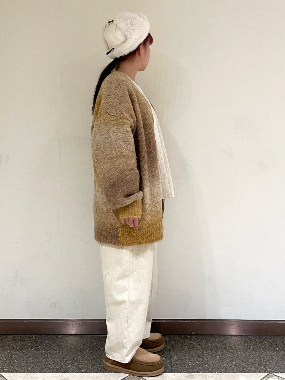イエロー系のその他シューズ、ホワイト系のハットを着用したレディースの冬コーディネートの5枚目の写真