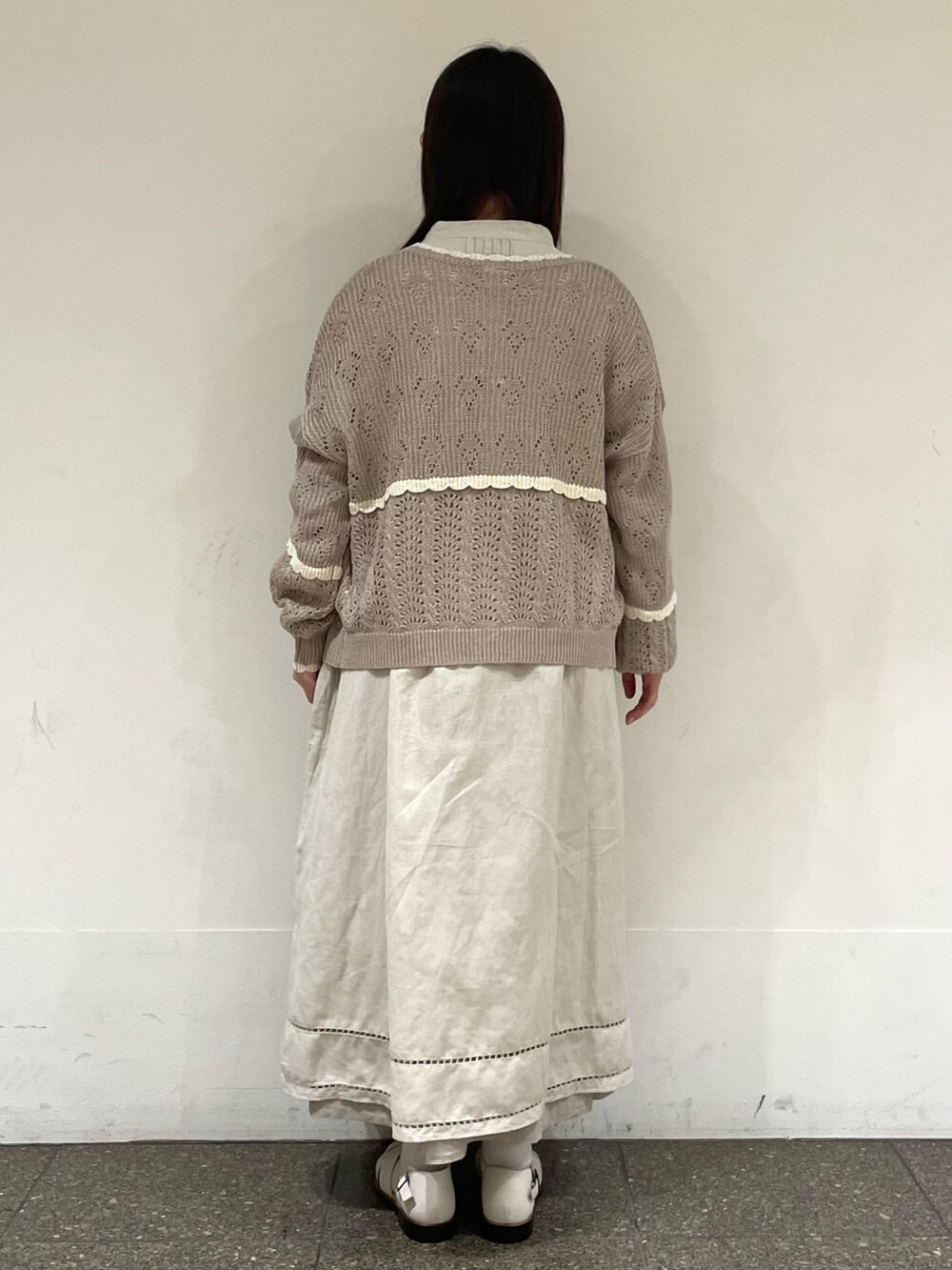 ホワイト系のサンダル、ベージュ系のカーディガン/ボレロ、グレー系のワンピースを着用したレディースの春コーディネートの4枚目の写真