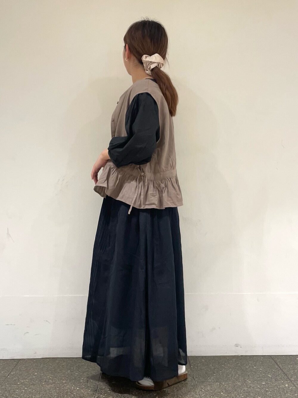 ブラック系のシャツ/ブラウス、ベージュ系のベスト、ブラック系のスカートを着用したレディースの夏コーディネートの2枚目の写真