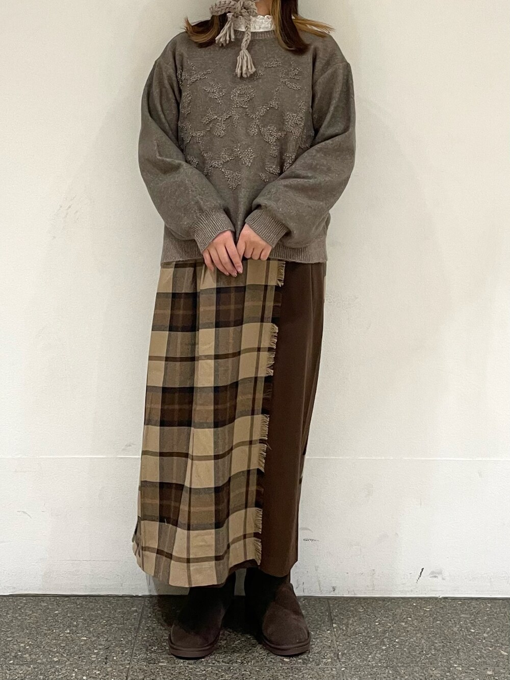 ホワイト系のTシャツ/カットソー、ブラウン系のカーディガン/ボレロ、ブラウン系のブーツを着用したレディースの冬コーディネートの2枚目の写真