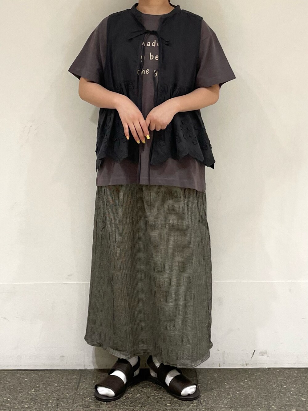 ブラウン系のサンダル、ブラウン系のTシャツ/カットソー、グレー系のベストを着用したレディースの秋コーディネートの2枚目の写真
