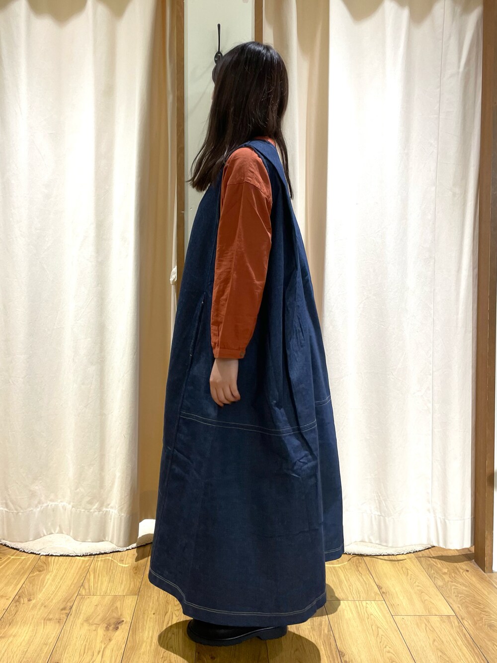 オレンジ系のシャツ/ブラウス、ブルー系のワンピース、ブラック系のその他シューズを着用したレディースの秋コーディネートの2枚目の写真