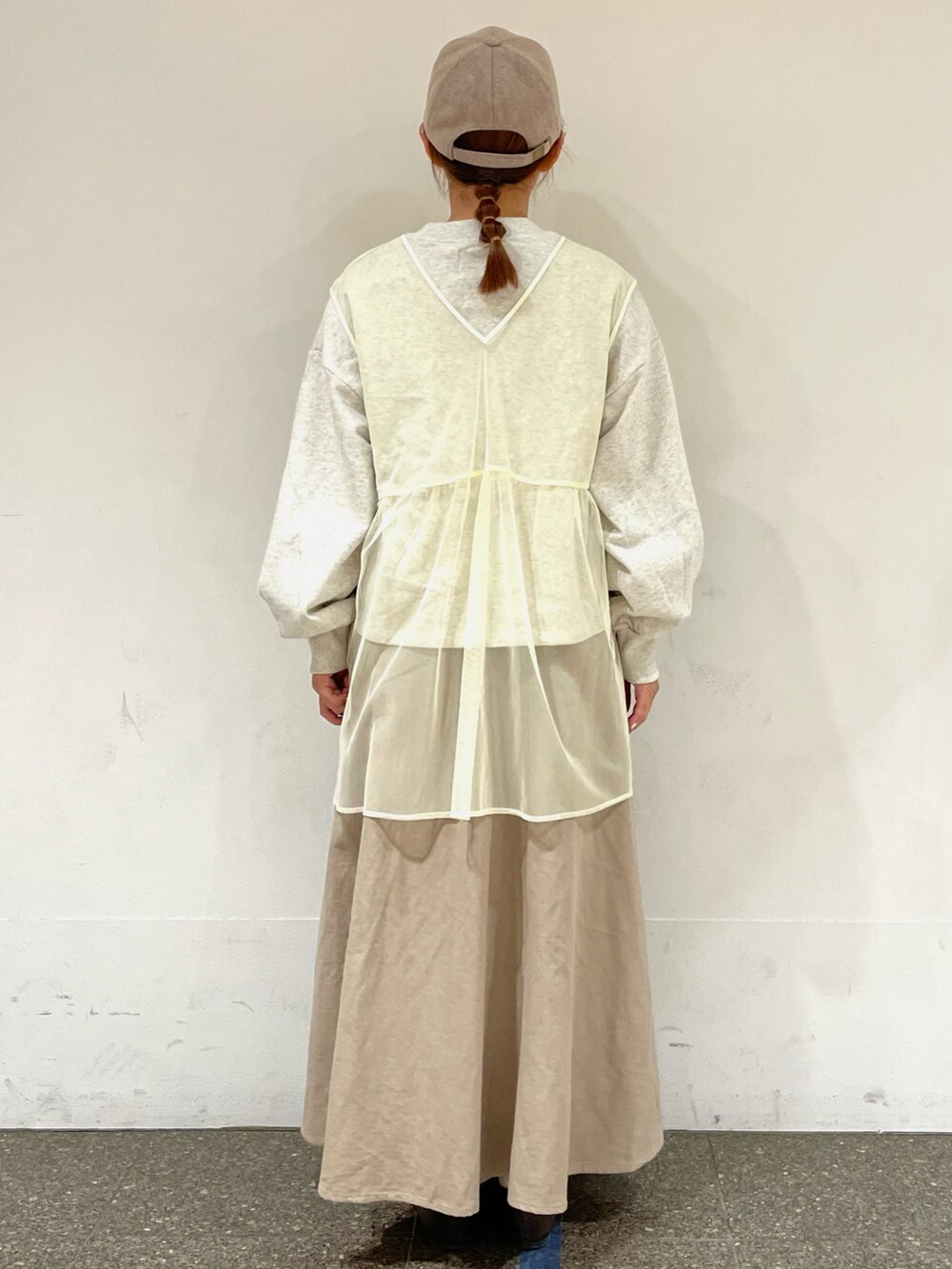 グレー系のTシャツ/カットソー、ホワイト系のベスト、ベージュ系のスカートを着用したレディースの秋コーディネートの4枚目の写真