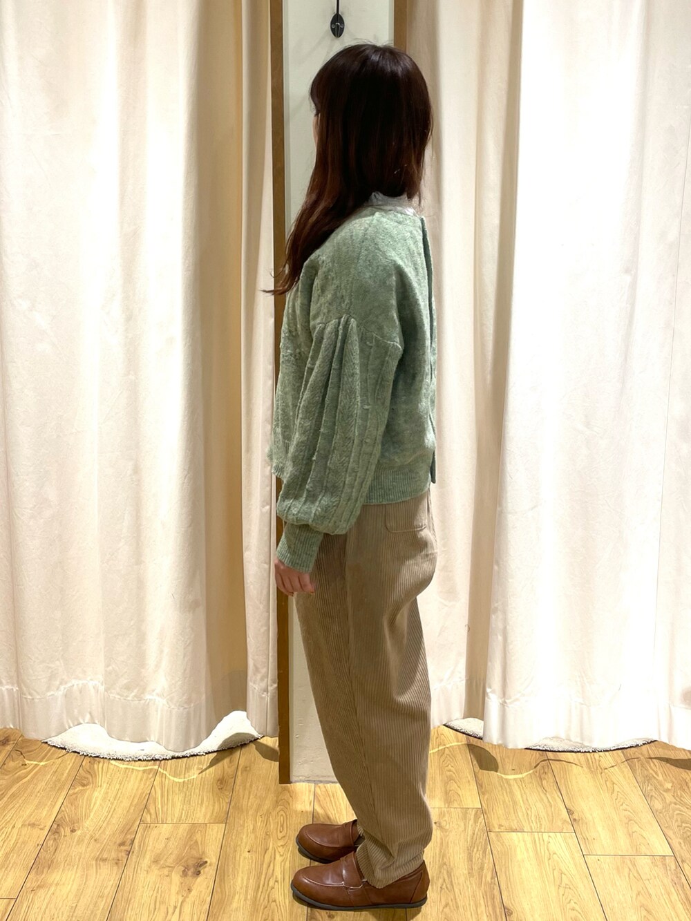 ホワイト系のシャツ/ブラウス、グリーン系のニット/セーター、ベージュ系のその他パンツを着用したレディースの冬コーディネートの2枚目の写真