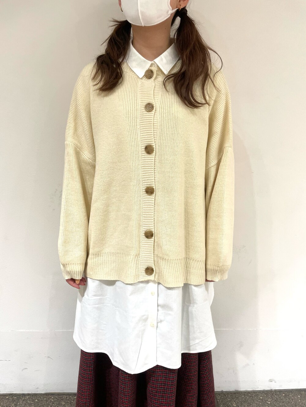 レッド系のスカート、ブラウン系のブーツ、ホワイト系のチュニックを着用したレディースの冬コーディネートの4枚目の写真