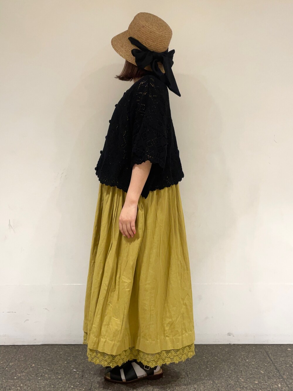 ブラック系のカーディガン/ボレロ、グリーン系のワンピース、ブラック系のサンダルを着用したレディースの春コーディネートの3枚目の写真