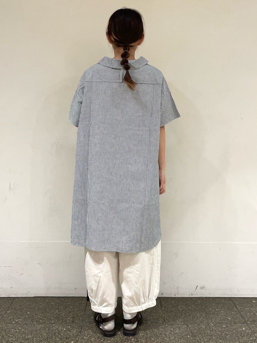 ブラウン系のサンダル、ホワイト系のその他パンツ、ベージュ系のハンドバッグを着用したレディースの秋コーディネートの4枚目の写真