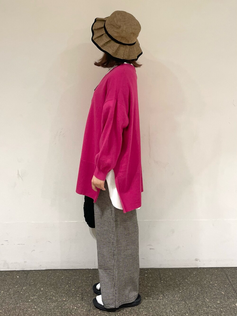 ホワイト系のTシャツ/カットソー、ピンク系のカーディガン/ボレロ、ブラック系のハンドバッグを着用したレディースの春コーディネートの2枚目の写真