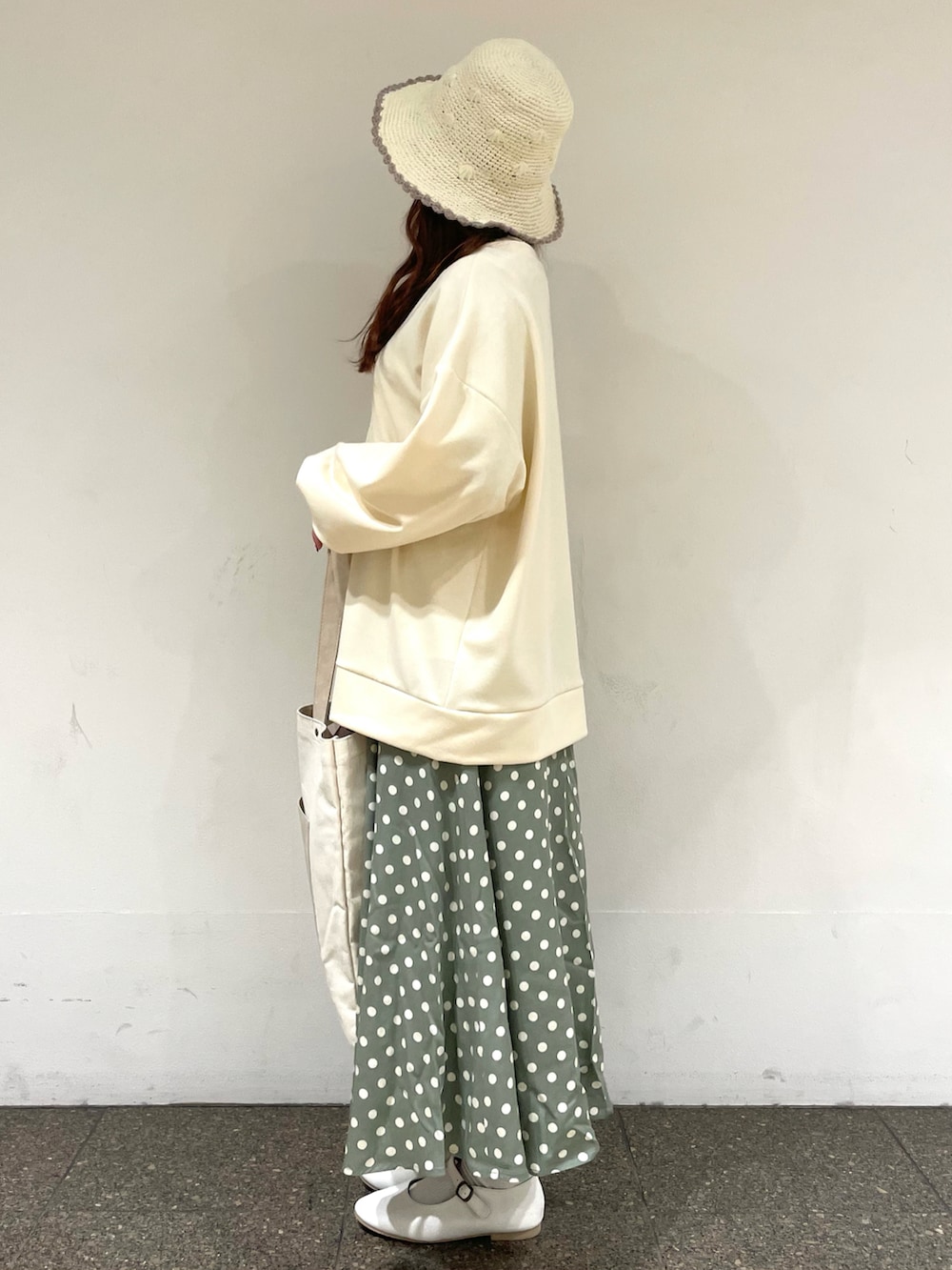 ホワイト系のTシャツ/カットソー、ホワイト系のカーディガン/ボレロ、ベージュ系のハンドバッグを着用したレディースの冬コーディネートの2枚目の写真