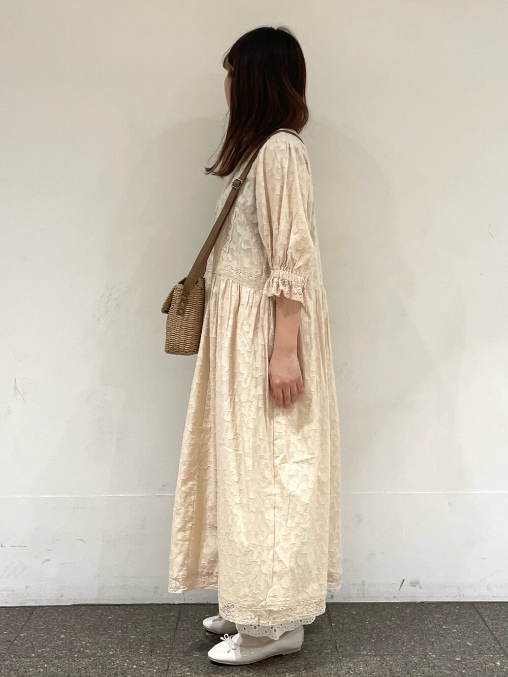 ホワイト系のパンプス、ホワイト系のワンピース、ベージュ系のハンドバッグを着用したレディースの春コーディネートの3枚目の写真