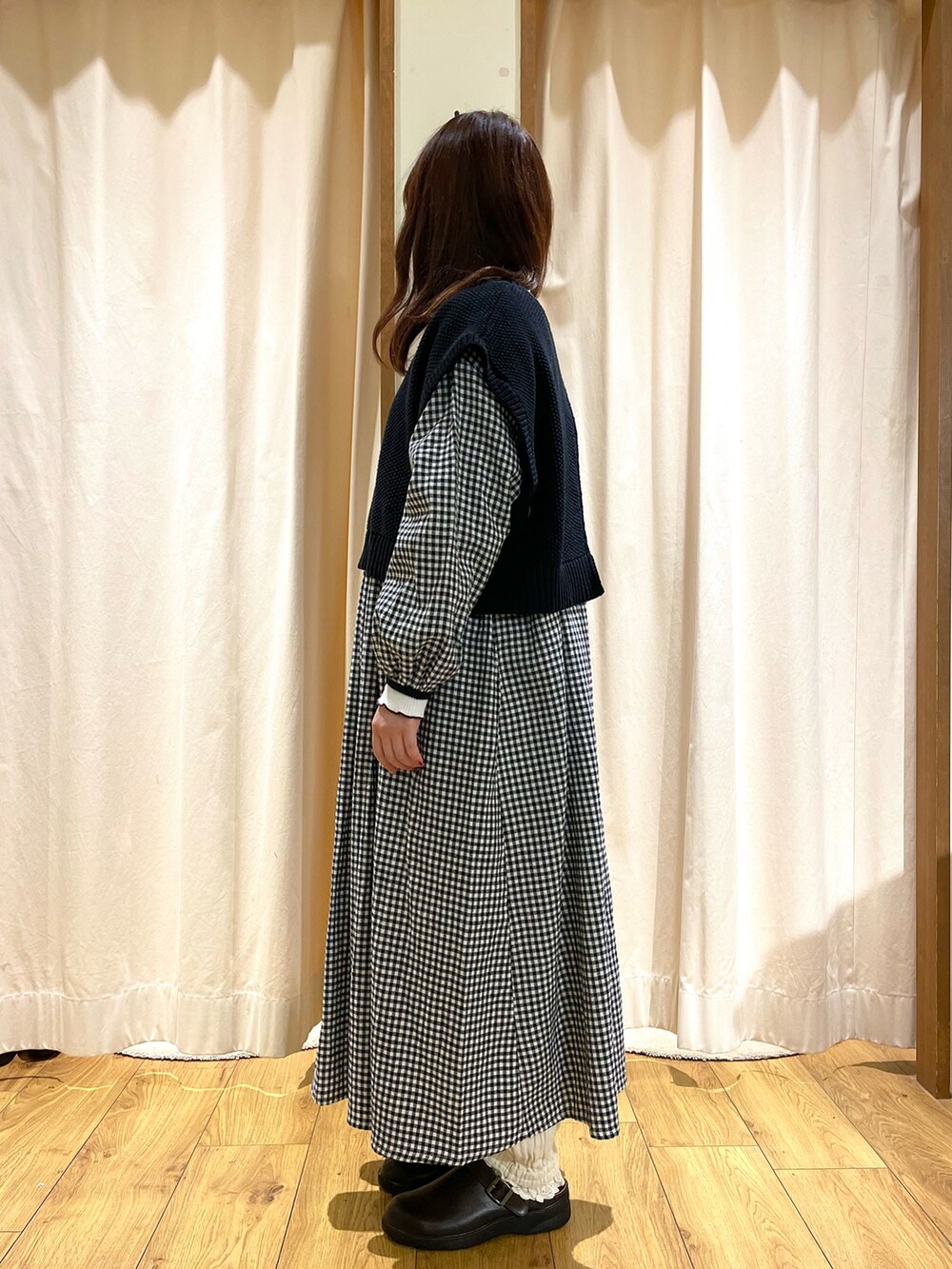 ブラック系のベスト、ブラック系のワンピース、ホワイト系のその他パンツを着用したレディースの冬コーディネートの2枚目の写真