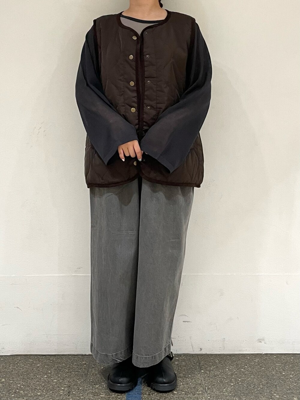 ブラック系のニット/セーター、ブラウン系のベスト、グレー系のデニムパンツを着用したレディースの秋コーディネートの2枚目の写真