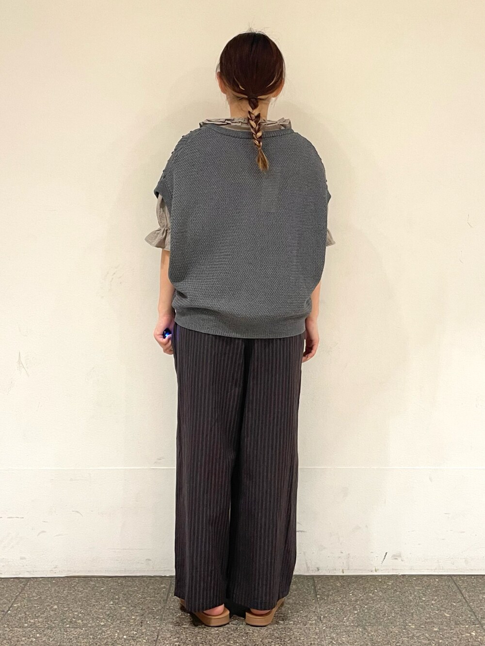 ブラウン系のサンダル、ベージュ系のシャツ/ブラウス、グレー系のベストを着用したレディースの秋コーディネートの4枚目の写真