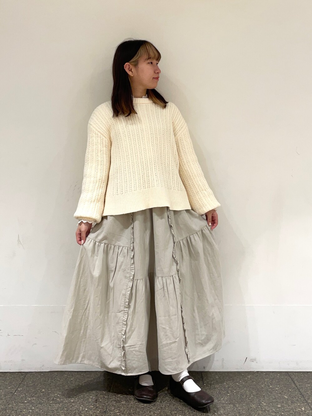 ブラウン系のドレスシューズ、ホワイト系のシャツ/ブラウス、ホワイト系のニット/セーターを着用したレディースの冬コーディネートの2枚目の写真