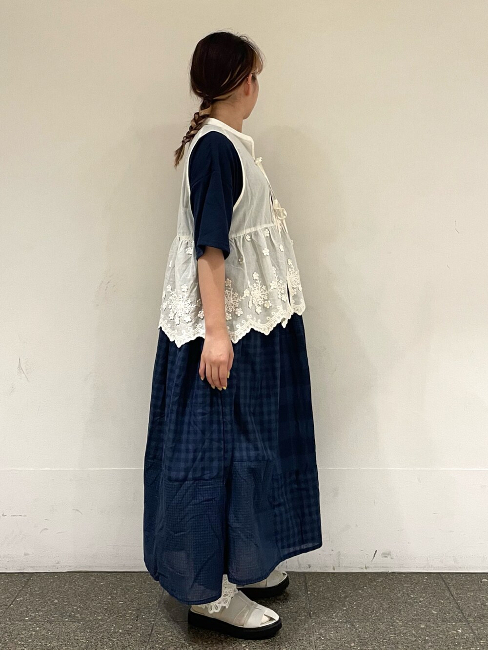 ホワイト系のサンダル、ホワイト系のベスト、ブルー系のワンピースを着用したレディースの秋コーディネートの5枚目の写真