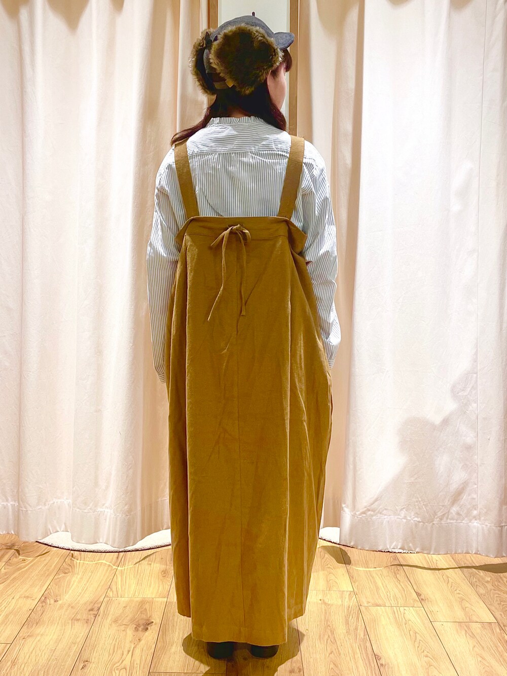 ホワイト系のシャツ/ブラウス、イエロー系のジャンパースカート、ブラウン系のサンダルを着用したレディースの秋コーディネートの3枚目の写真