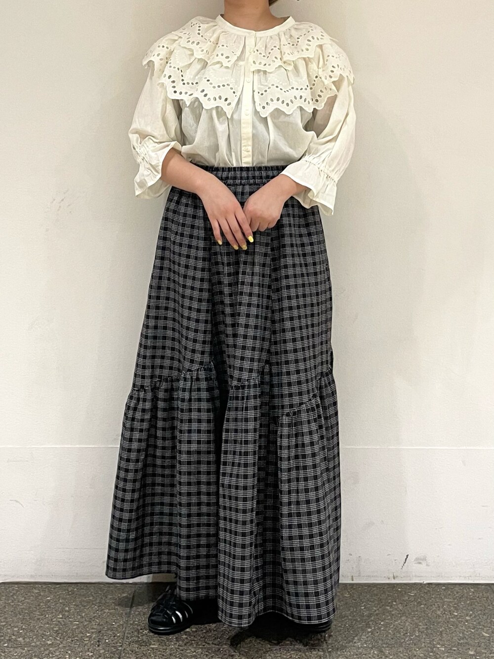 ホワイト系のシャツ/ブラウス、ブラック系のスカート、ブラック系のサンダルを着用したレディースの秋コーディネートの2枚目の写真