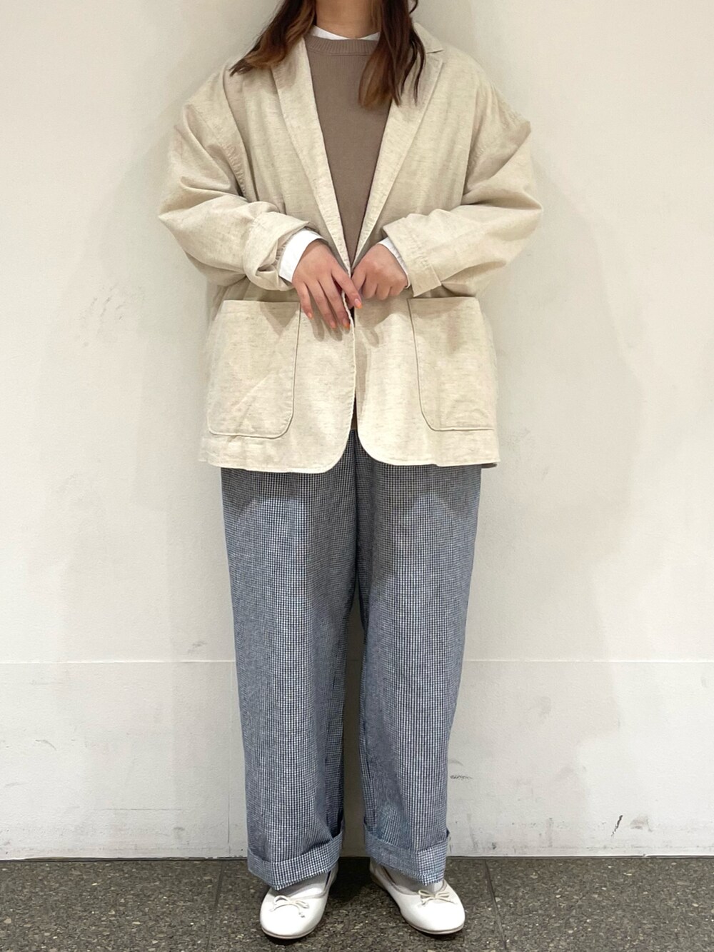 ホワイト系のパンプス、ホワイト系のシャツ/ブラウス、ベージュ系のベストを着用したレディースの春コーディネートの2枚目の写真