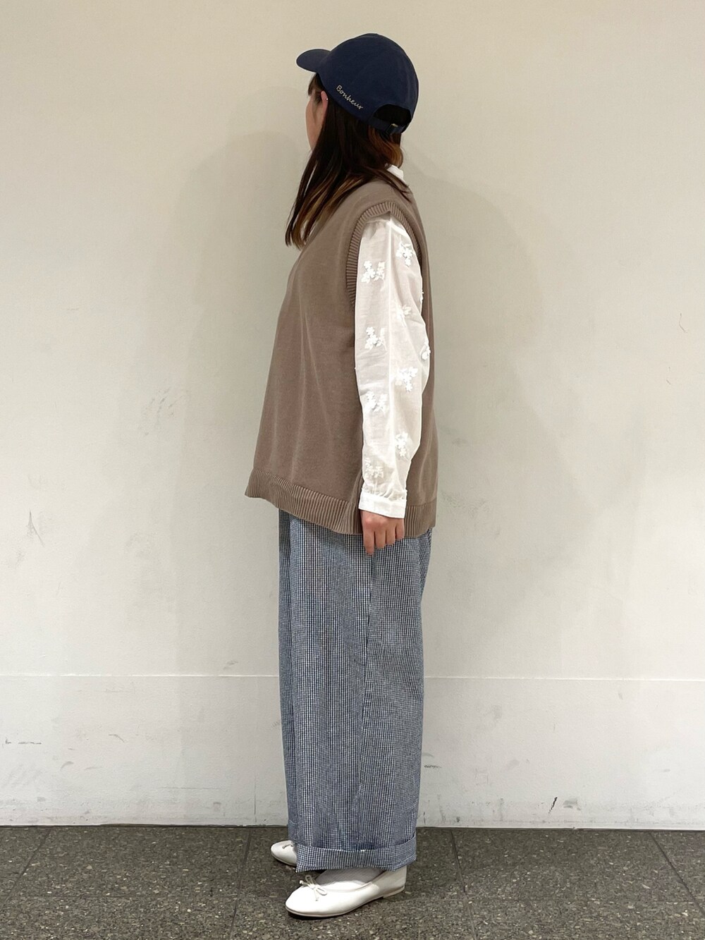 ホワイト系のシャツ/ブラウス、ベージュ系のベスト、ブルー系のその他パンツを着用したレディースの春コーディネートの3枚目の写真
